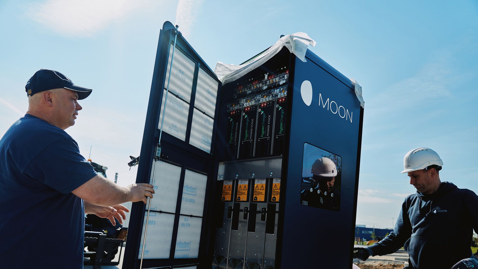 Dva moška izvajata montažo hitre polnilne postaje.