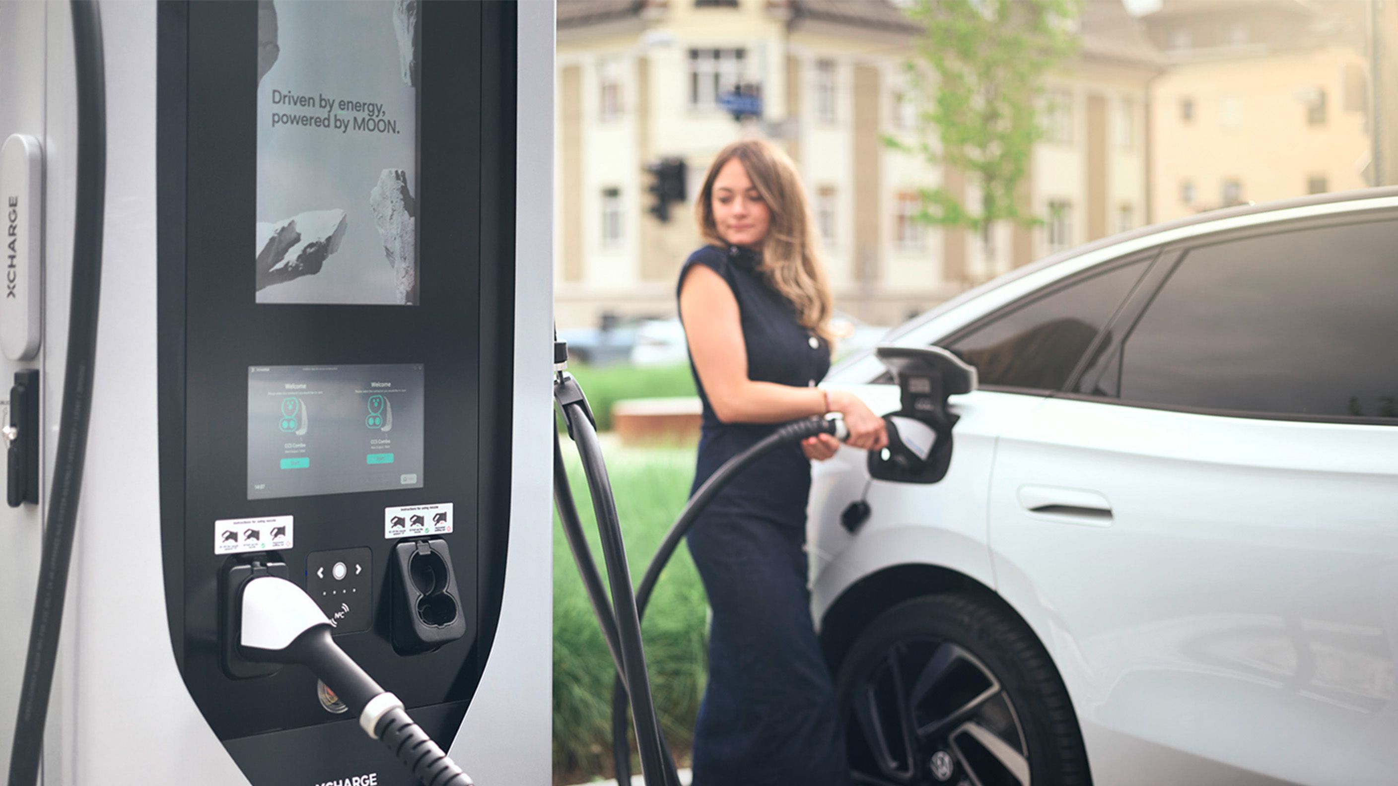 Woman charging e-car with a fast charging station