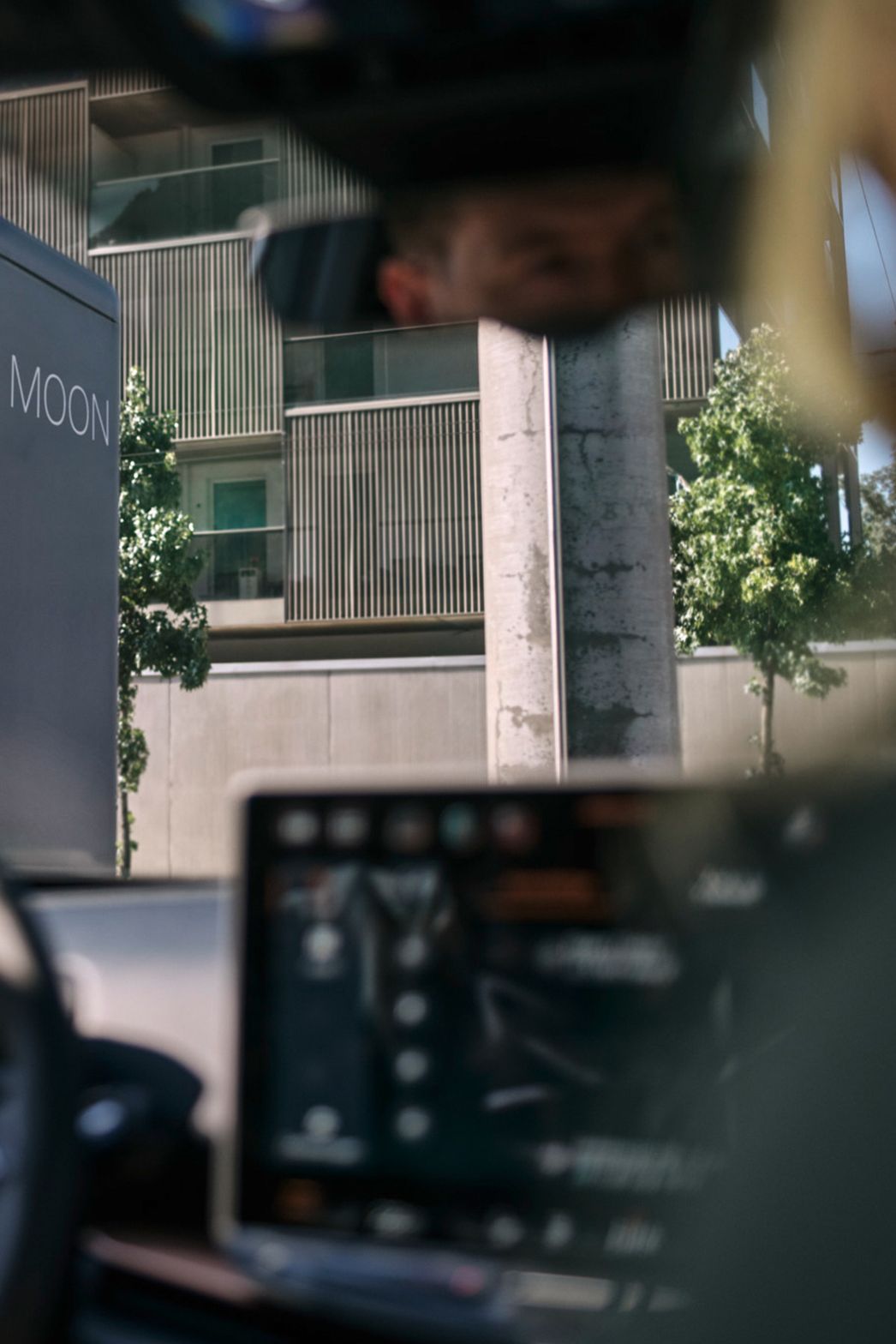 Dve osebi sedita v električnem vozilu pred hitro polnilno postajo.