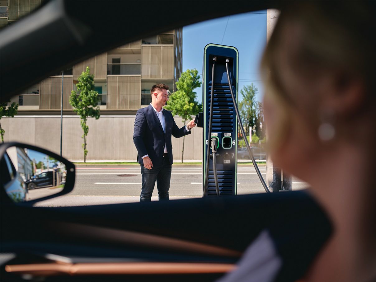 Moški drži kartico na hitro polnilnico