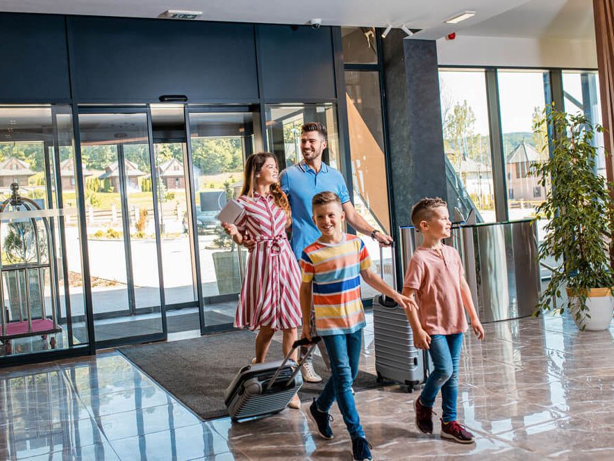 Družina z dvema otrokoma prihaja v hotel.