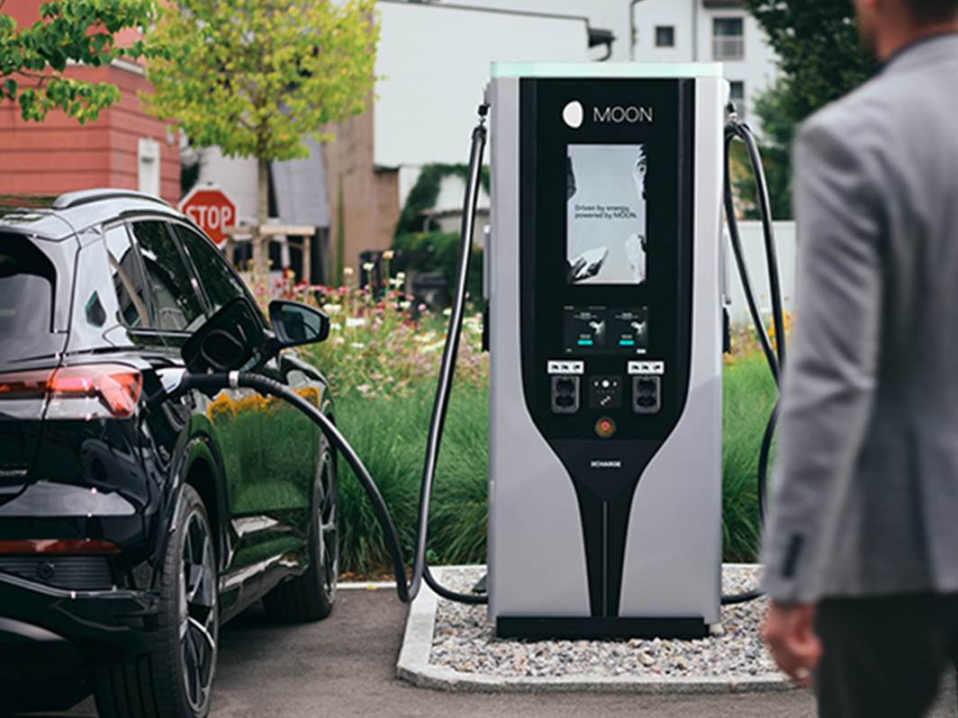 Oseba hodi proti hitri polnilni postaji